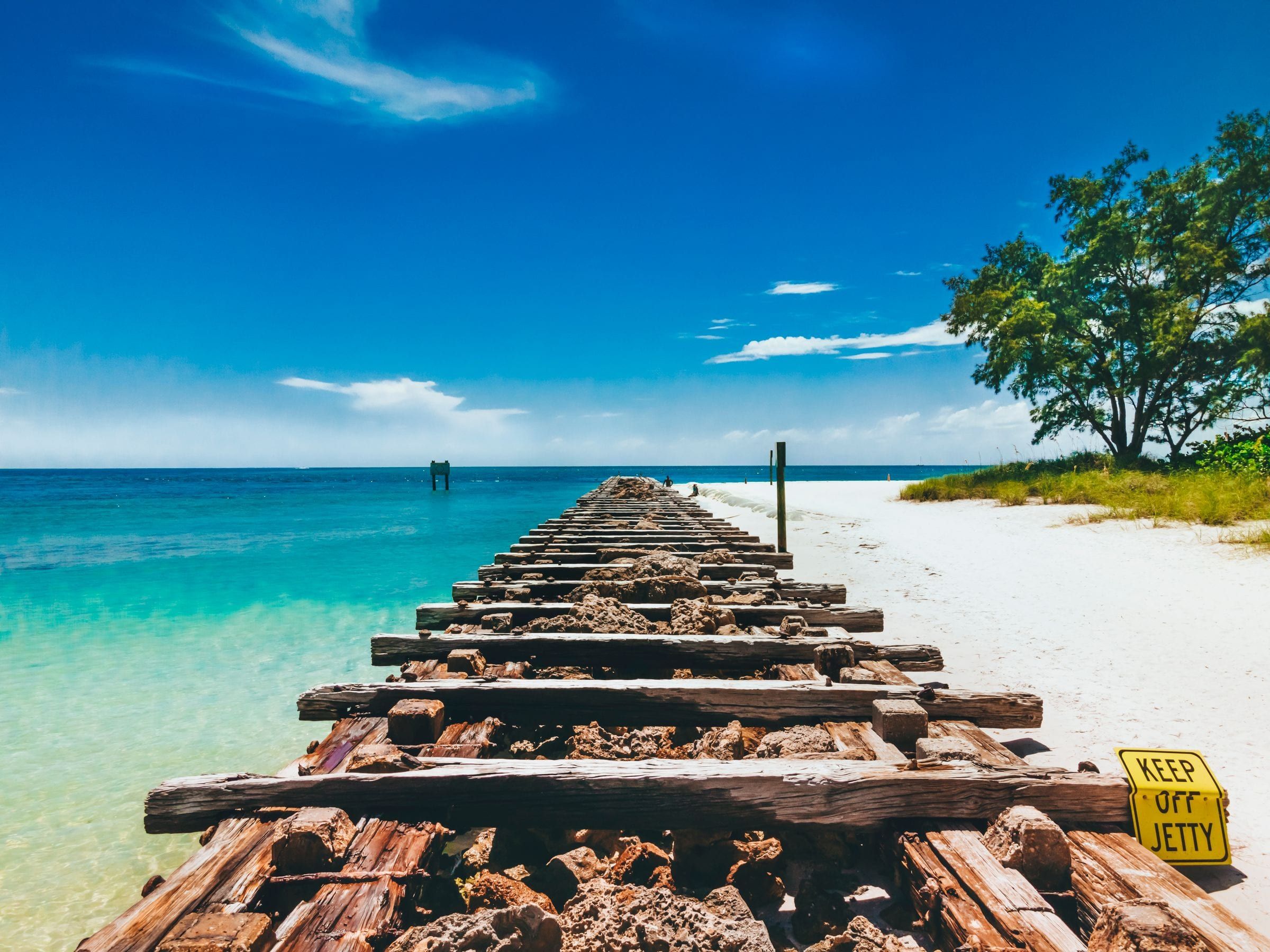 Old wooden jetty on the white sand of Bradenton Beach in Manatee County, Florida