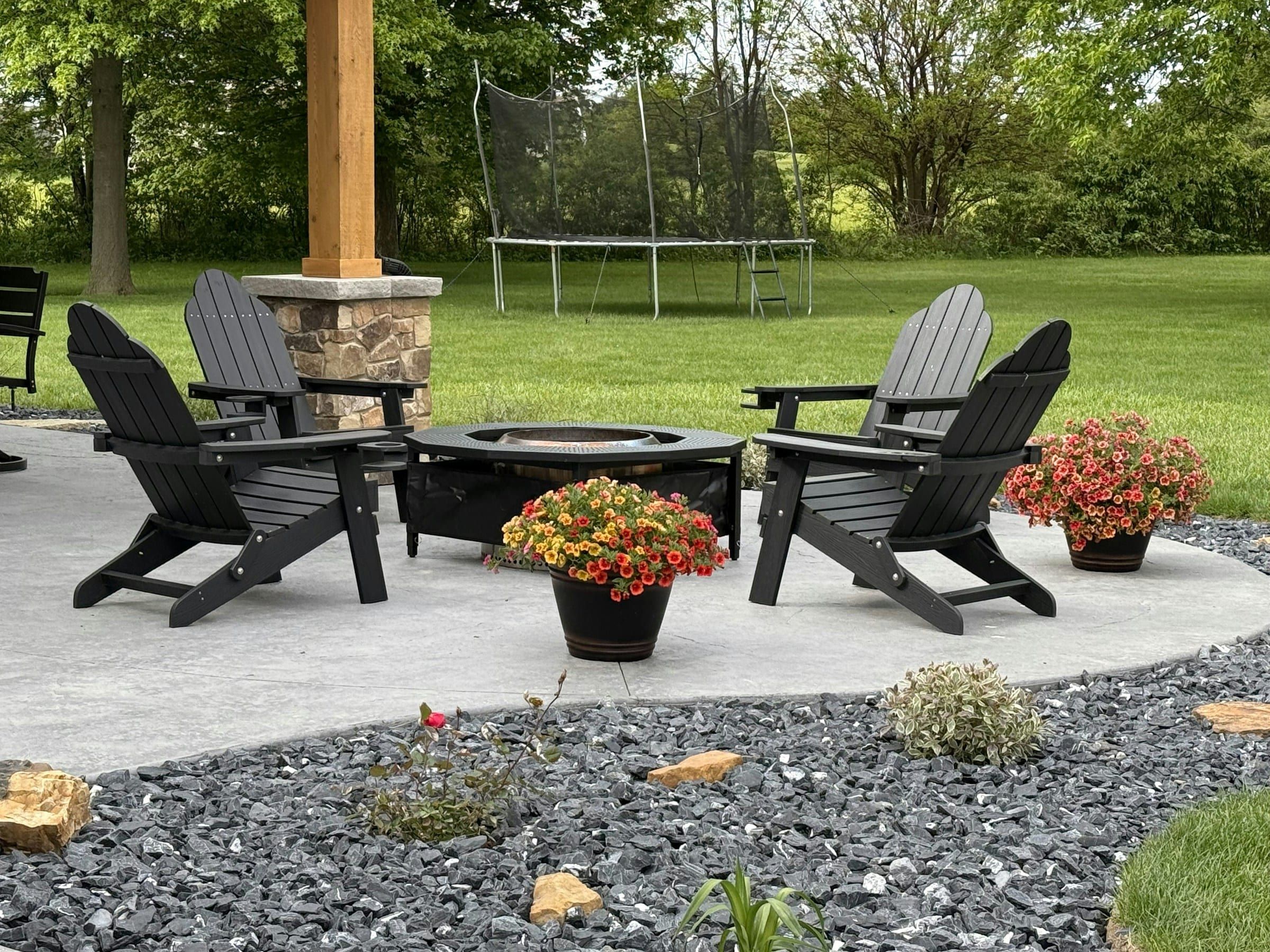 Backyard fire pit with Adirondack chairs on a stone patio