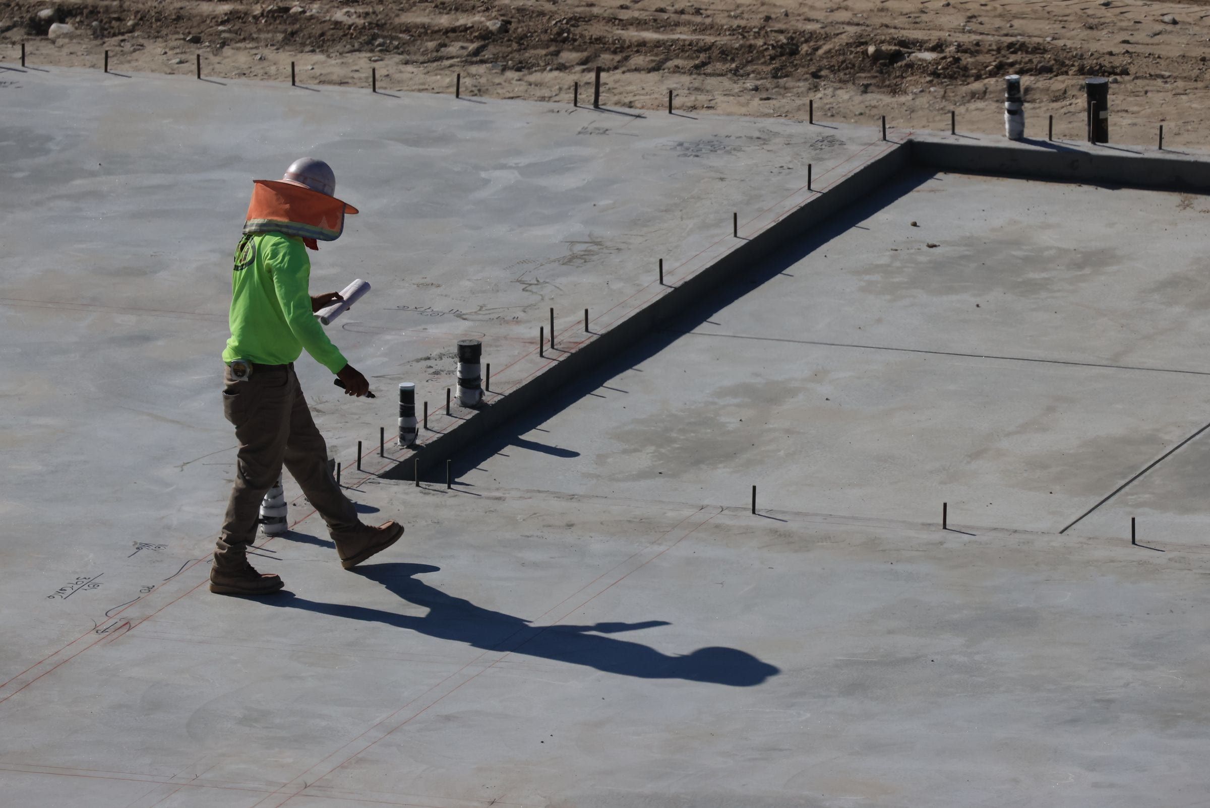 Builder checking the new slab with the plumbing stubbed up