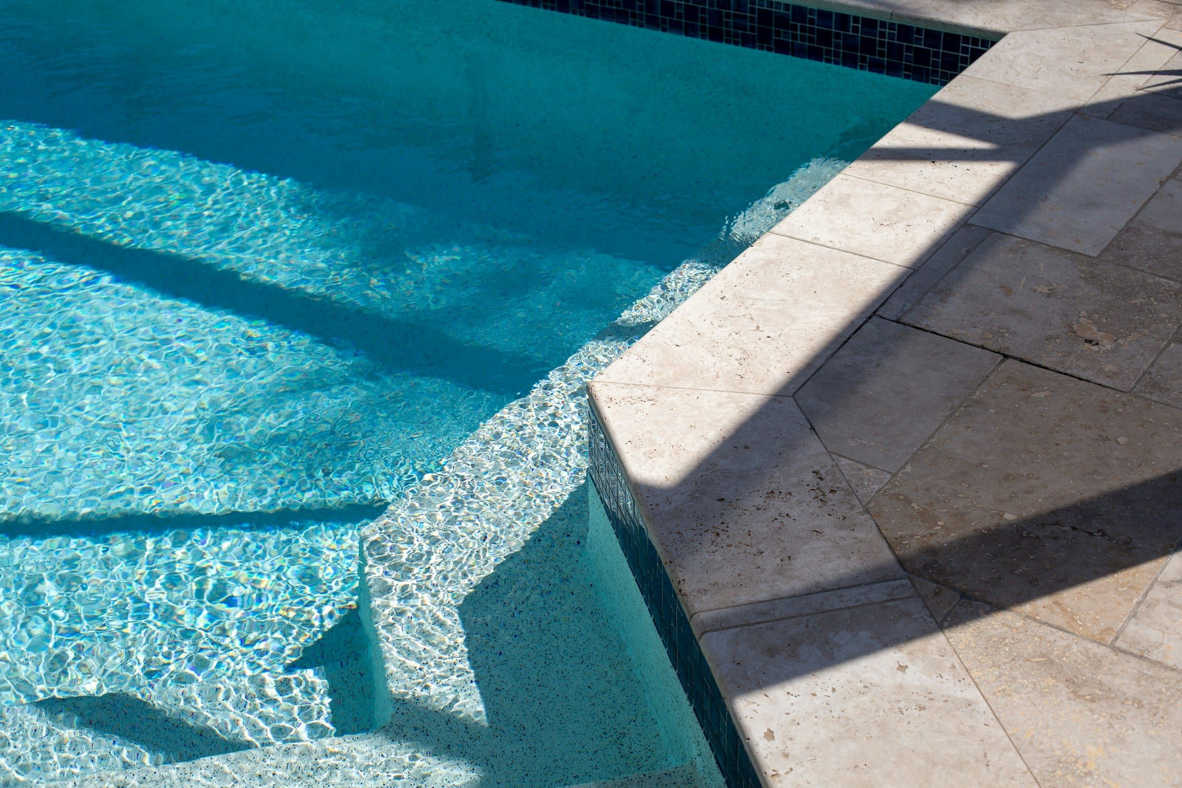 New interior finish and travertine coping at the pool steps