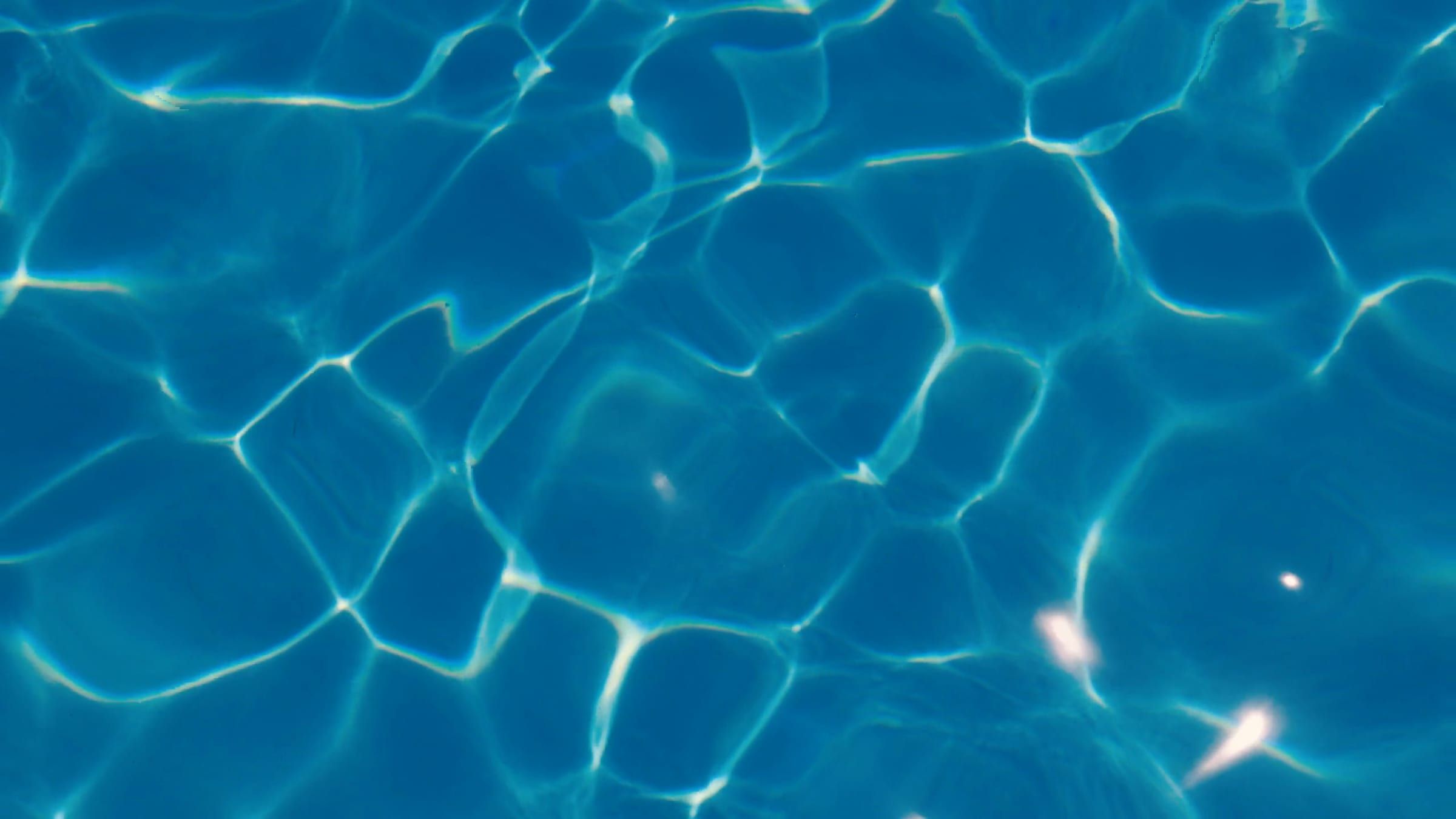 Sunlight rippling on clear turquoise pool water